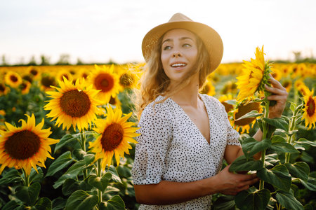 Beautiful woman posing in a field of sunflowers in a dress. Fashion, lifestyle, travel concept.の写真素材