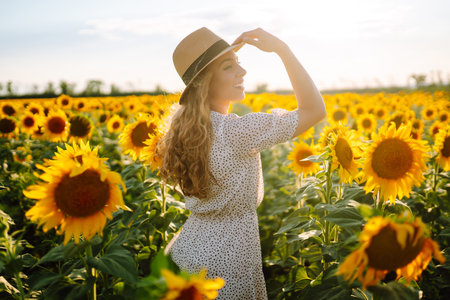 Beautiful woman posing in a field of sunflowers in a dress. Fashion, lifestyle, travel concept.の写真素材