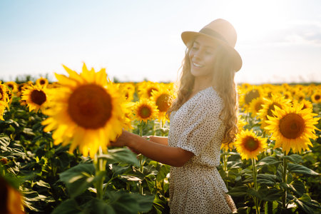 Beautiful woman posing in a field of sunflowers in a dress. Fashion, lifestyle, travel concept.の写真素材
