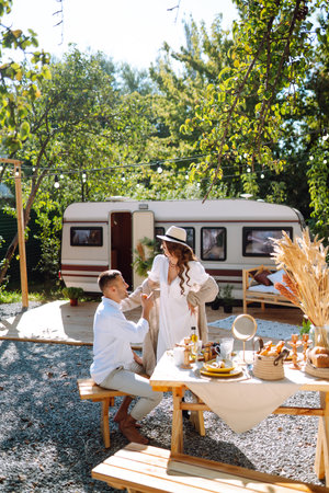 Beautiful wedding couple laugh and kiss relaxing in rv, camping in a trailer. Romantic moment.の写真素材