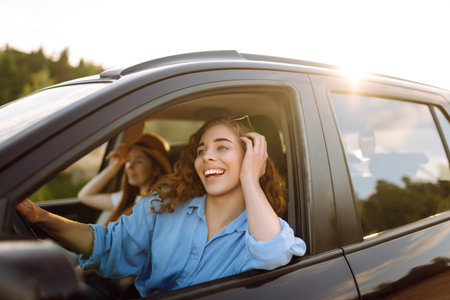Two young women on car trip having fun. Lifestyle, travel, tourism, nature, active life.の写真素材