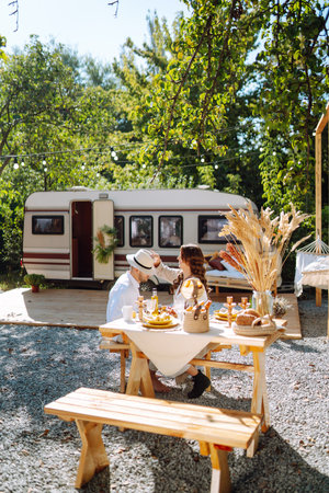 Beautiful wedding couple laugh and kiss relaxing in rv, camping in a trailer. Romantic moment.の写真素材