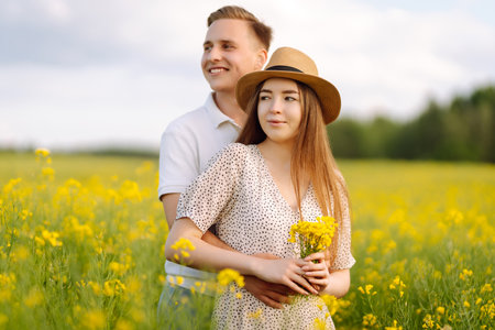 Young couple in love walks through a rapeseed field. The concept of love, test, relationship.の写真素材