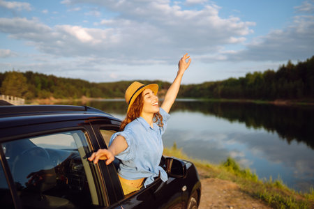 Towards adventure! Young woman is resting and enjoying the trip in car. Lifestyle, travel, active life.の写真素材