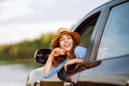 Towards adventure! Young woman is resting and enjoying the trip in car. Lifestyle, travel, active life.の写真素材