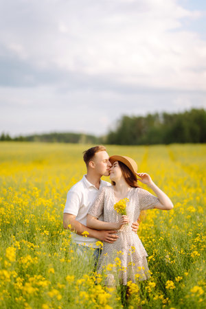 Young couple in love walks through a rapeseed field. The concept of love, test, relationship.の写真素材