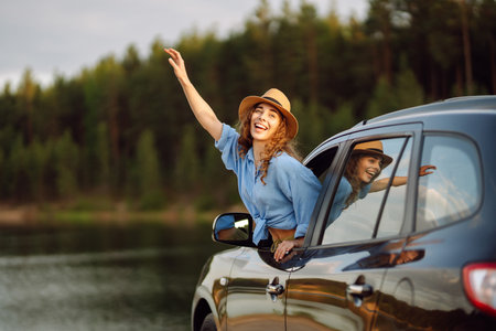 Towards adventure! Young woman is resting and enjoying the trip in car. Lifestyle, travel, active life.の写真素材