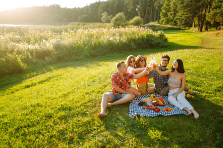 Happy group of friends resting in nature in picnic. People, lifestyle, relaxation, vacations concept.の写真素材