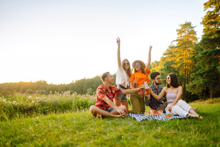Happy group of friends resting in nature in picnic. People, lifestyle, relaxation, vacations concept.の写真素材