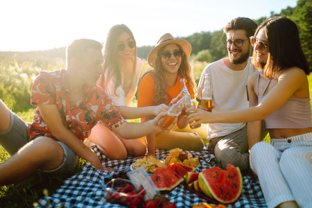 Happy group of friends resting in nature in picnic. People, lifestyle, relaxation, vacations concept.の写真素材