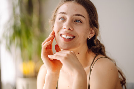 Woman worry about her face when she saw the problem of acne occur by a mini mirror. Pimples, acneの写真素材