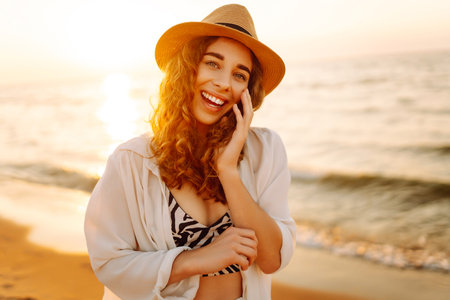 Happy woman on beach in summer style fashion trend outfit carefree and happy, feeling freedom.の写真素材