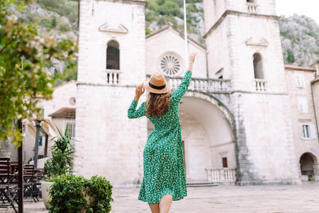 Happy female tourist in beautiful dress walking in the street of the city. Fashion style. Travel.の写真素材