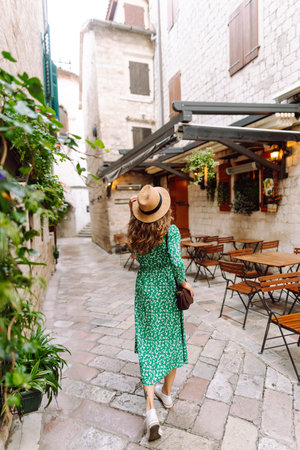 Young woman in beautiful dress walking in the street of the city. Eurotrip. Travel, tourism. Fashionの写真素材
