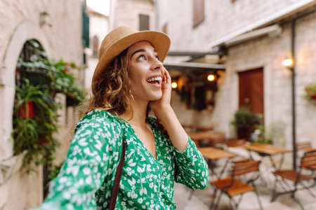 Beautiful woman walks the streets and takes selfie using smartphone cameraの写真素材