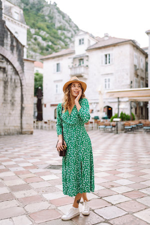 Young woman in beautiful dress walking in the street of the city. Eurotrip. Travel, tourism. Fashionの写真素材