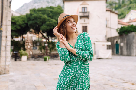 Happy female tourist in beautiful dress walking in the street of the city. Fashion style. Travel.の写真素材