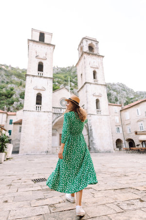 Happy female tourist in beautiful dress walking in the street of the city. Fashion style. Travel.の写真素材