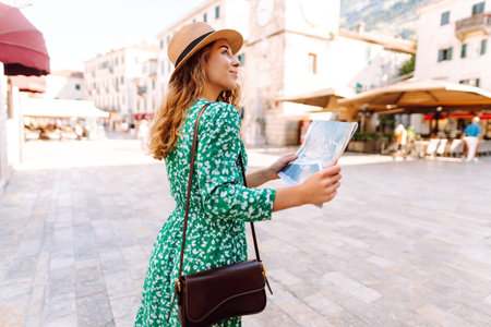 Portrait beautiful woman with paper map on urban street. Exploring interesting places to travel.の写真素材