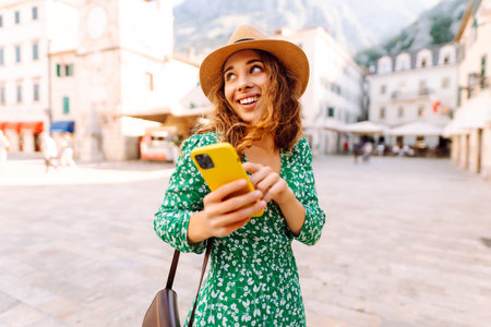 Pretty woman walks the streets with mobile phone. Tourist using mobile app searching way.の写真素材