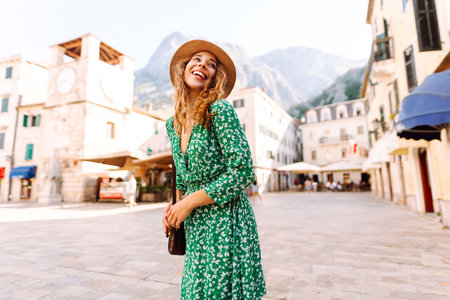 Happy smiling woman wearing trendy summer outfit walking in street of European city. Lifestyle.の写真素材