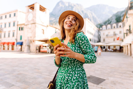 Pretty woman walks the streets with mobile phone. Tourist using mobile app searching way.の写真素材