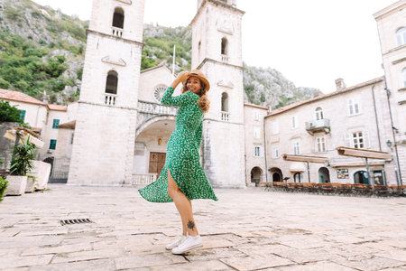 Happy female tourist in beautiful dress walking in the street of the city. Fashion style. Travel.の写真素材