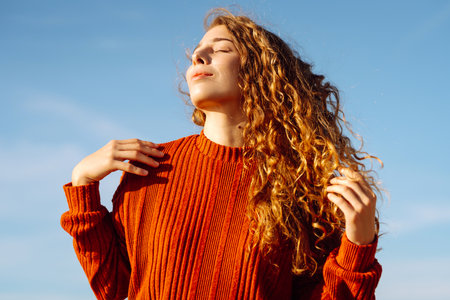 Outdoor portrait of pretty woman on the beach in cold sunny weather. Travel, fashion, bloggingの写真素材