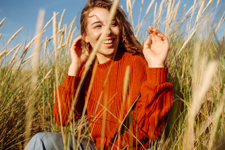 Beauty woman enjoying nature outdoors in grass. Calmness and tranquility. Travel, tourism concept.の写真素材