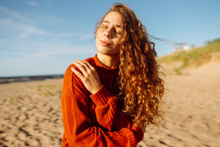 Outdoor portrait of pretty woman on the beach in cold sunny weather. Travel, fashion, bloggingの写真素材