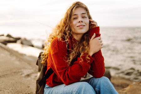 Portrait of woman enjoying a breezy day near the sea at sunset. Lifestyle concept.の写真素材