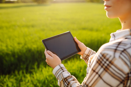 A young woman agronomist checks the growth of the crop. Concept of gardening, ecology.の写真素材