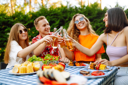 Happy friends in picnic in park. Friends grill meat, have fun, relax. ?concept of holidays, weekends.の写真素材
