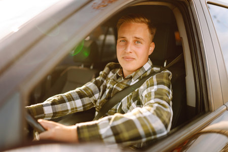 Happy man feeling comfortable sitting on driver seat in car. Lifestyle concept. Car sharing concept.の写真素材