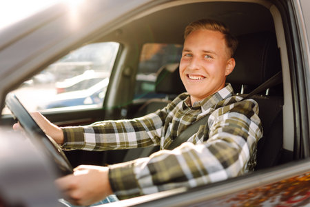 Happy man feeling comfortable sitting on driver seat in car. Lifestyle concept. Car sharing concept.の写真素材