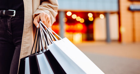 Beauty woman with shopping bags walks through the sunny streets of Europe. Consumerism, shoppingの写真素材