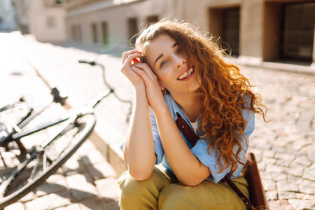 Portrait of smiling woman sitting next to bike on street city. Travel, weekend and lifestyle conceptの写真素材