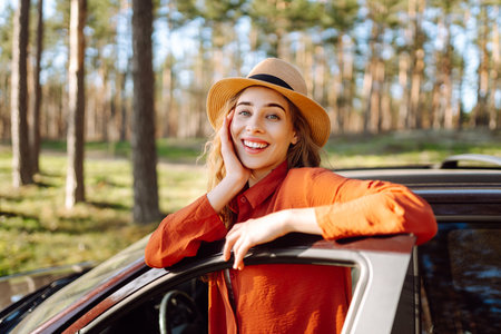Stopping during a car trip. Young woman enjoying nature. Journey by car. Lifestyle, travel, tourismの写真素材