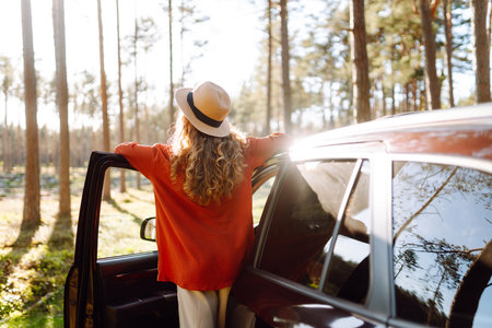 Stopping during a car trip. Young woman enjoying nature. Journey by car. Lifestyle, travel, tourismの写真素材