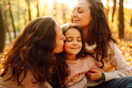 The family playing with her daughter in the autumn forest. The adventure is more fun.の写真素材