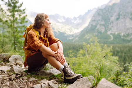 Female legs in hiking boots on hiking trail, on top of mountain outdoors. Nature, relaxation conceptの写真素材
