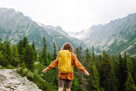 Smiling traveler with a bright backpack on a hiking mountain trail. Active lifestyle.の写真素材