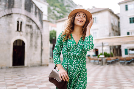 Young woman in beautiful dress walking in the street of the city. Travel, tourism. Fashionの写真素材