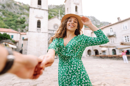 Follow me concept and traveling together. Girl traveler wearing dress, holds the boyfriend's handの写真素材