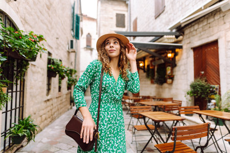 Young woman in beautiful dress walking in the street of the city. Eurotrip. Travel, tourism. Fashionの写真素材