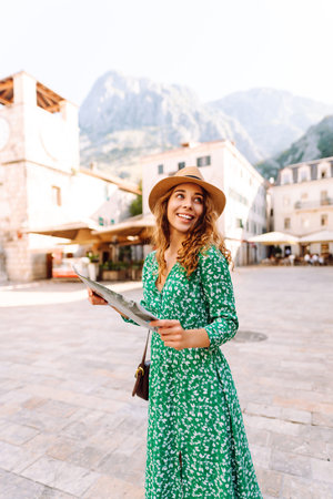 Portrait beautiful woman with paper map on urban street. Exploring interesting places to travel.の写真素材