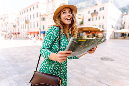 Portrait beautiful woman with paper map on urban street. Exploring interesting places to travel.の写真素材