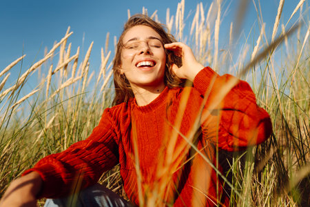 Beauty woman enjoying nature outdoors in grass. Calmness and tranquility. Travel, tourism concept.