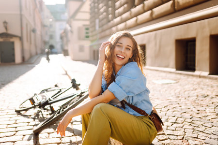 Beautiful smiling woman sitting next to bike on the street city. Adventure Conceptの写真素材