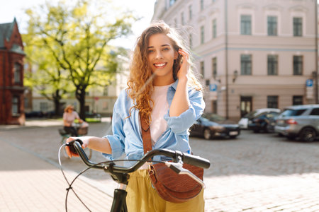 Beautiful woman riding bicycle at the city street outdoor. Active lifestyle. Eco transport.の写真素材